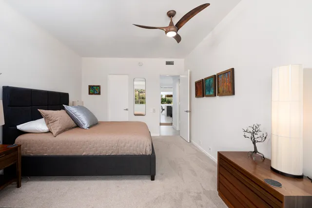 a bedroom with a bed a couch and a flat tv screen