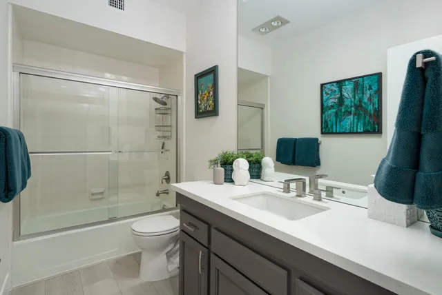 a bathroom with a granite countertop sink toilet and shower