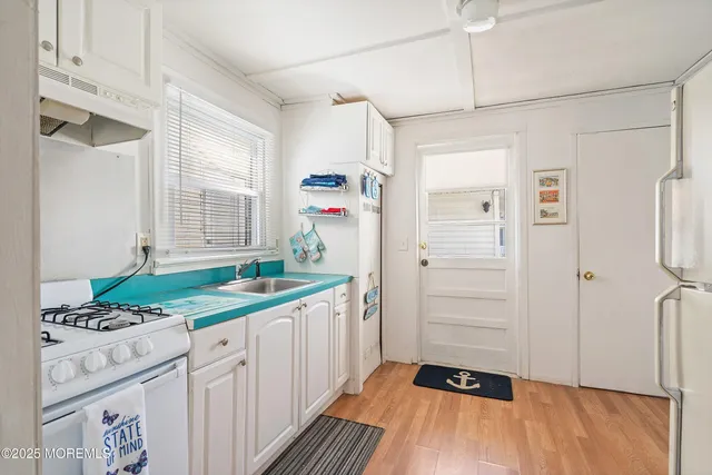 a storage room with wooden floor and way to room