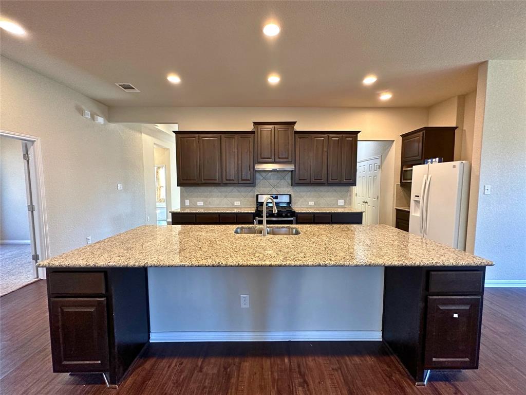 3117 Hidalgo Loop Round Rock, TX 78665 - Photo 10 of 27 a kitchen with kitchen island granite countertop wooden cabinets a refrigerator and a sink