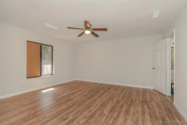 wooden floor in an empty room with a window