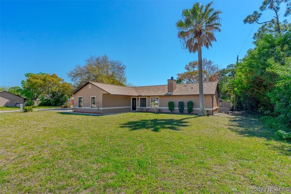 a front view of a house with a garden and yard