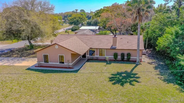 an aerial view of a house with swimming pool next to a yard