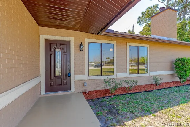 a view of a house with a small yard and wooden floor