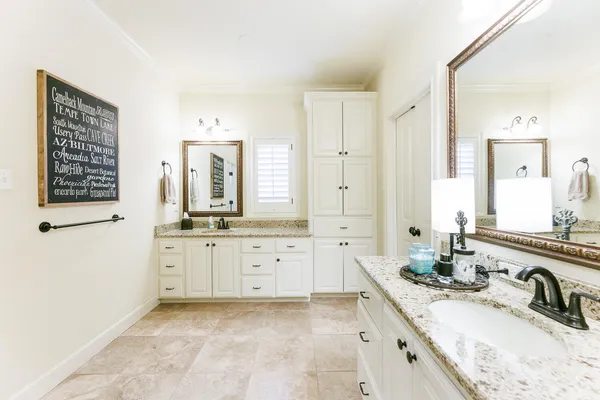 a bathroom with granite countertop a sink double vanity granite tub shower and a mirror