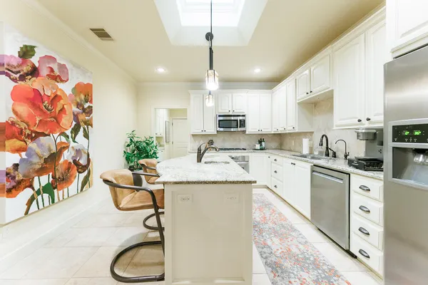 a kitchen with stainless steel appliances kitchen island granite countertop a sink and cabinets