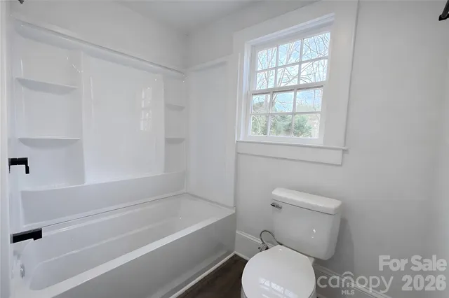 a bathroom with a toilet and a bath tub
