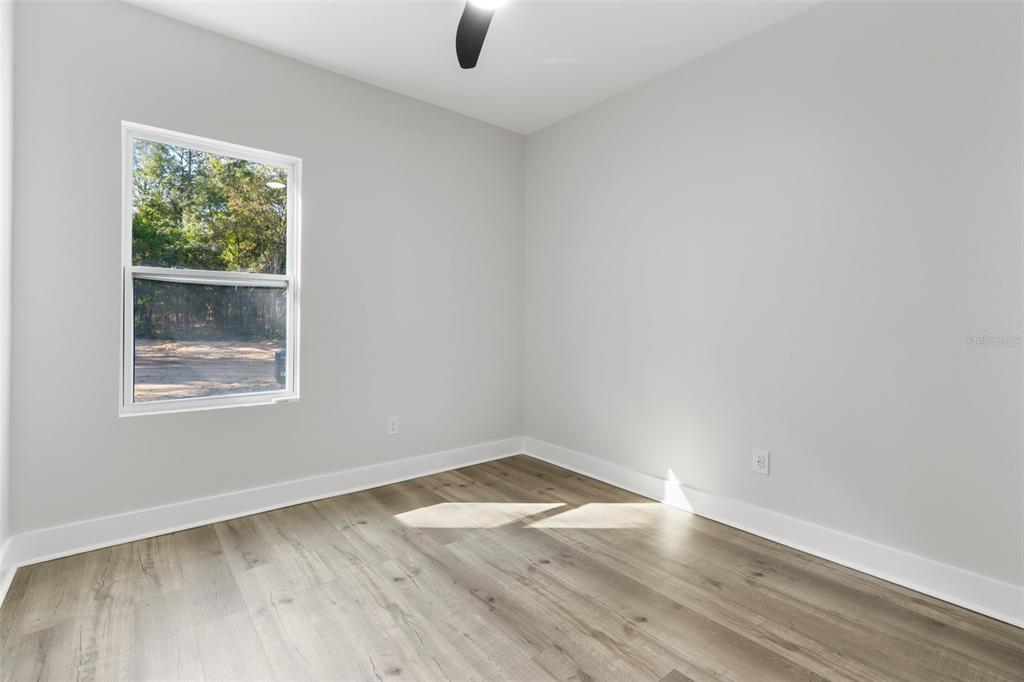 12248 Southwest 96th Lane Dunnellon, FL 34432 - Photo 14 of 26 an empty room with wooden floor and windows