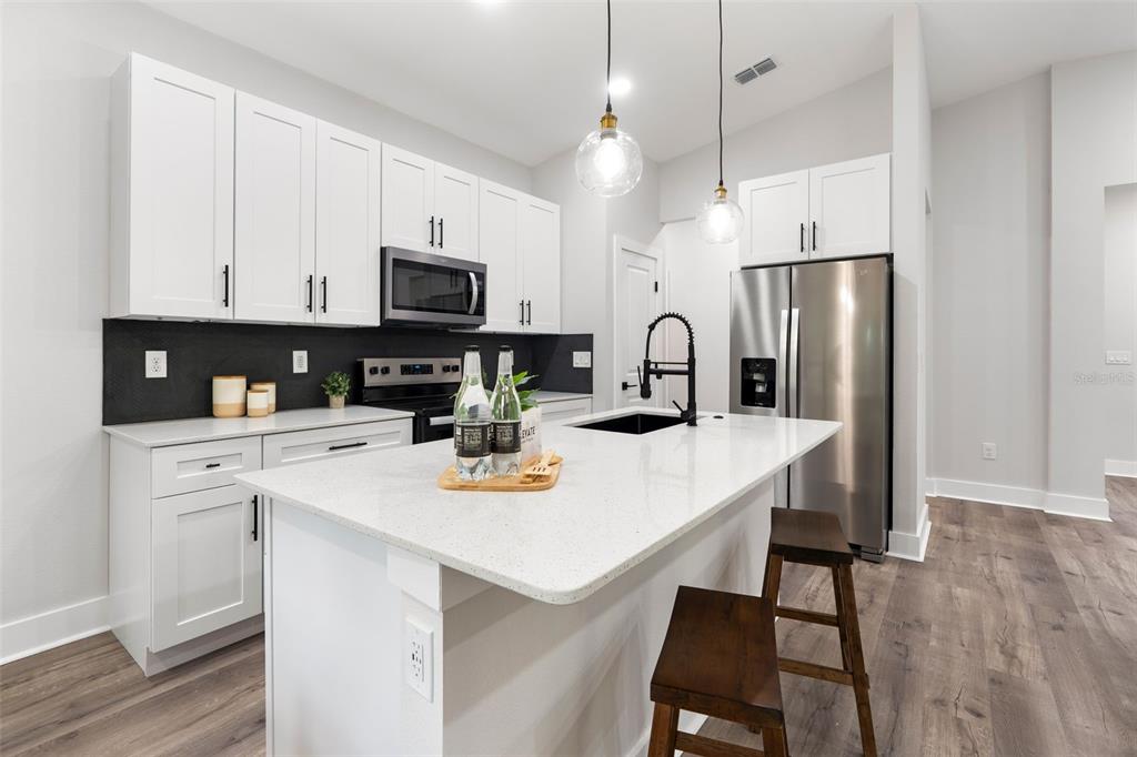 12248 Southwest 96th Lane Dunnellon, FL 34432 - Photo 9 of 26 a kitchen with stainless steel appliances a stove a sink a microwave a refrigerator and white cabinets
