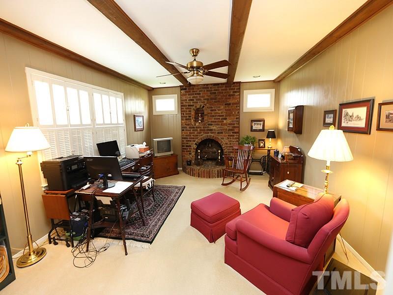 4916 Skidmore Street Raleigh, NC 27609 - Photo 6 of 12 a living room with furniture a fireplace and a flat screen tv