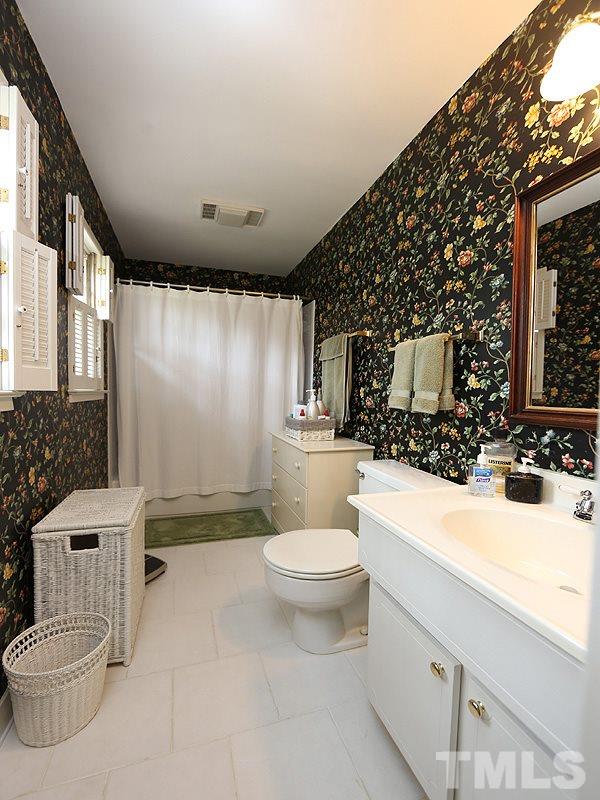 4916 Skidmore Street Raleigh, NC 27609 - Photo 8 of 12 a bathroom with a sink a toilet and shower