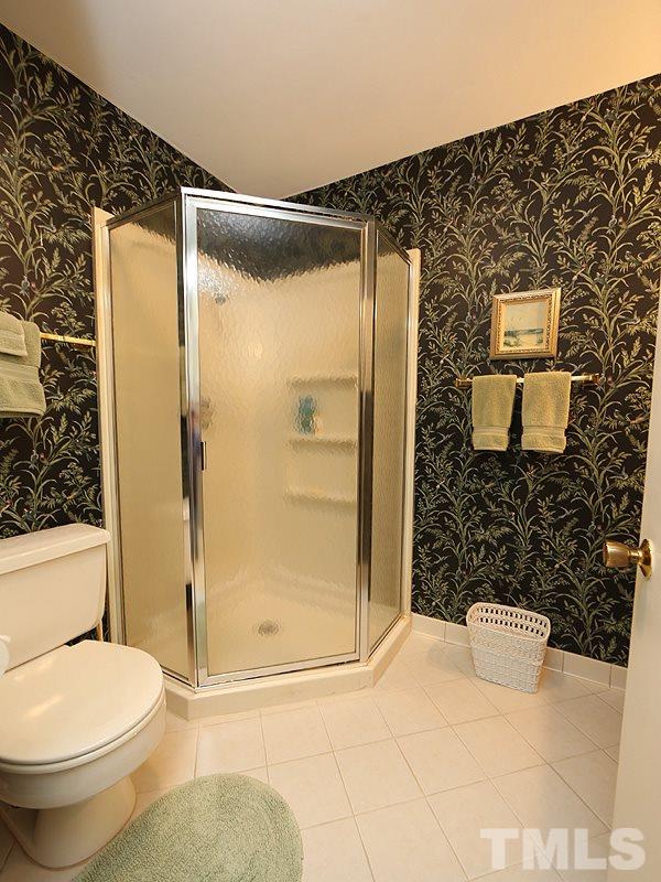 4916 Skidmore Street Raleigh, NC 27609 - Photo 10 of 12 a bathroom with a shower and a toilet