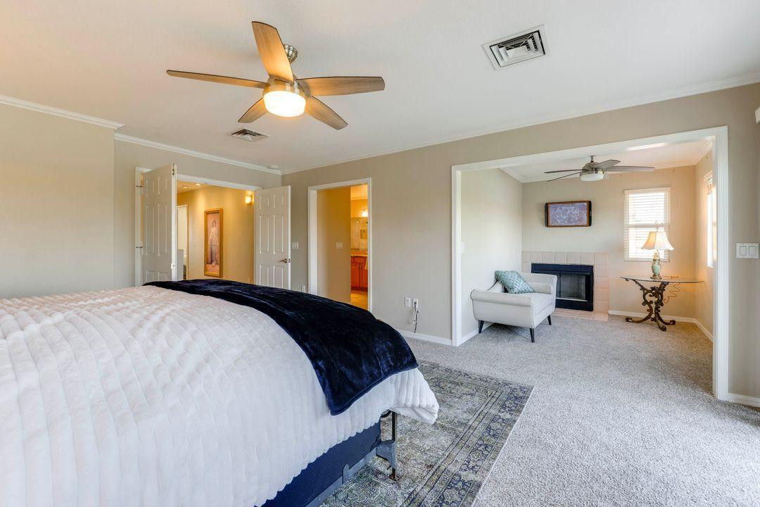 16439 South 34th Way Phoenix, AZ 85048 - Photo 23 of 33 a spacious bedroom with a bed and a chandelier