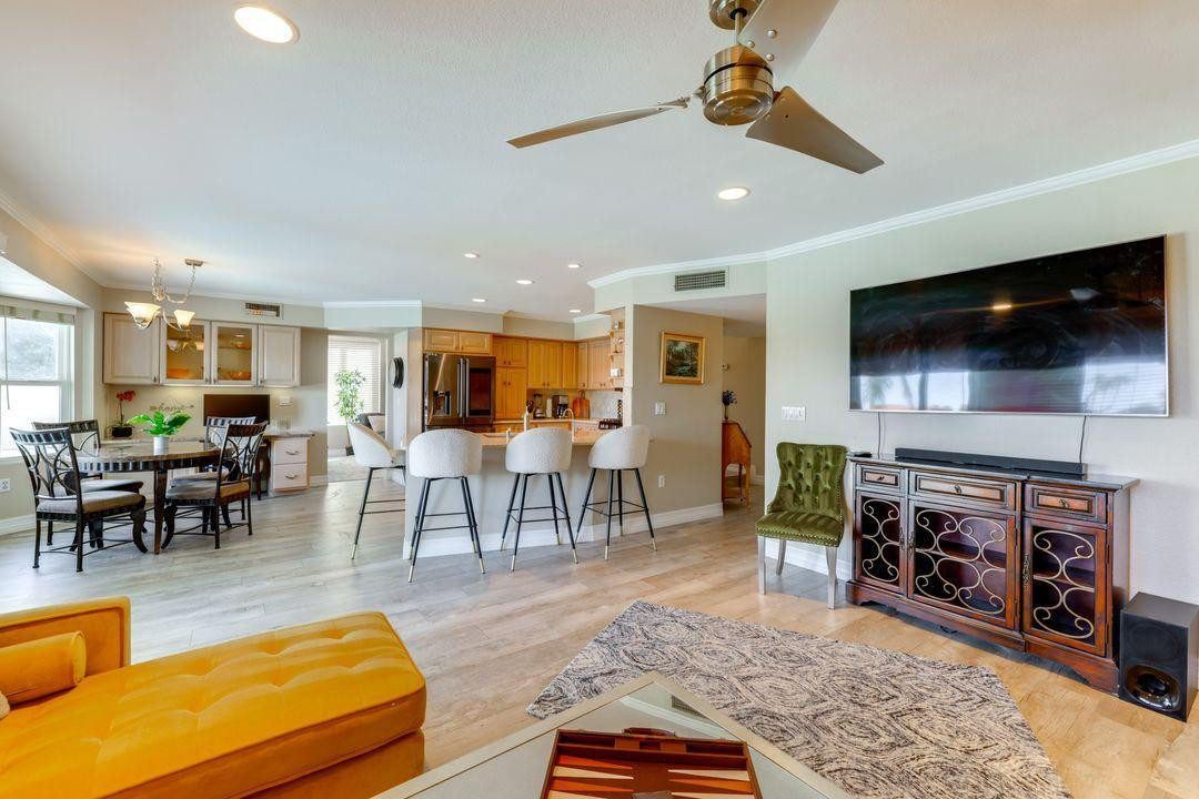 16439 South 34th Way Phoenix, AZ 85048 - Photo 3 of 33 a living room with furniture a flat screen tv and kitchen view