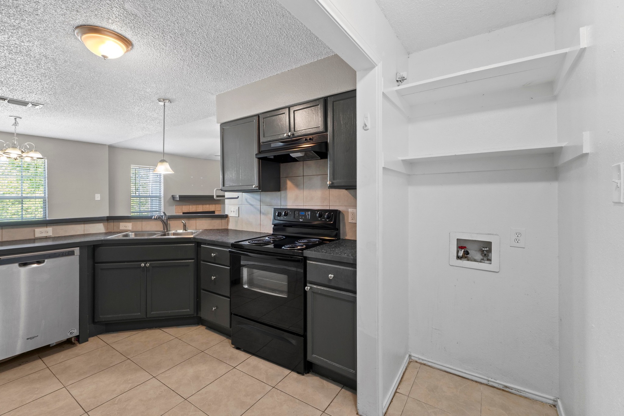 4208 Duval Road, Unit C Austin, TX 78759 - Photo 10 of 28 Kitchen with dark countertops, black range with electric cooktop, dishwasher, light tile patterned floors, and under cabinet range hood