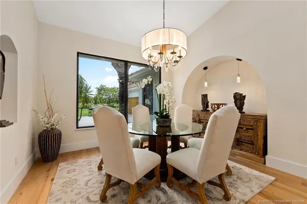 a living room with furniture kitchen view and a chandelier