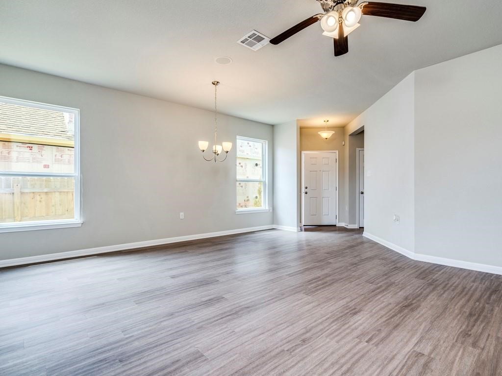 4210 Birdwatch Loop, Unit 2 Pflugerville, TX 78660 - Photo 4 of 31 A spacious, naturally illuminated area features durable plank flooring and a classic chandelier.
