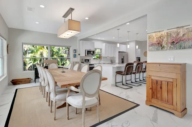 a dining room with furniture a large window and wooden floor