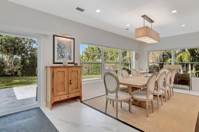a dining room with furniture and a floor to ceiling window