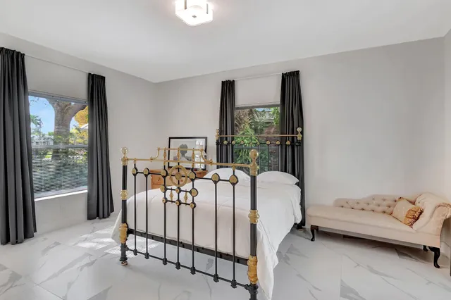 a bed sitting in a bedroom next to a window