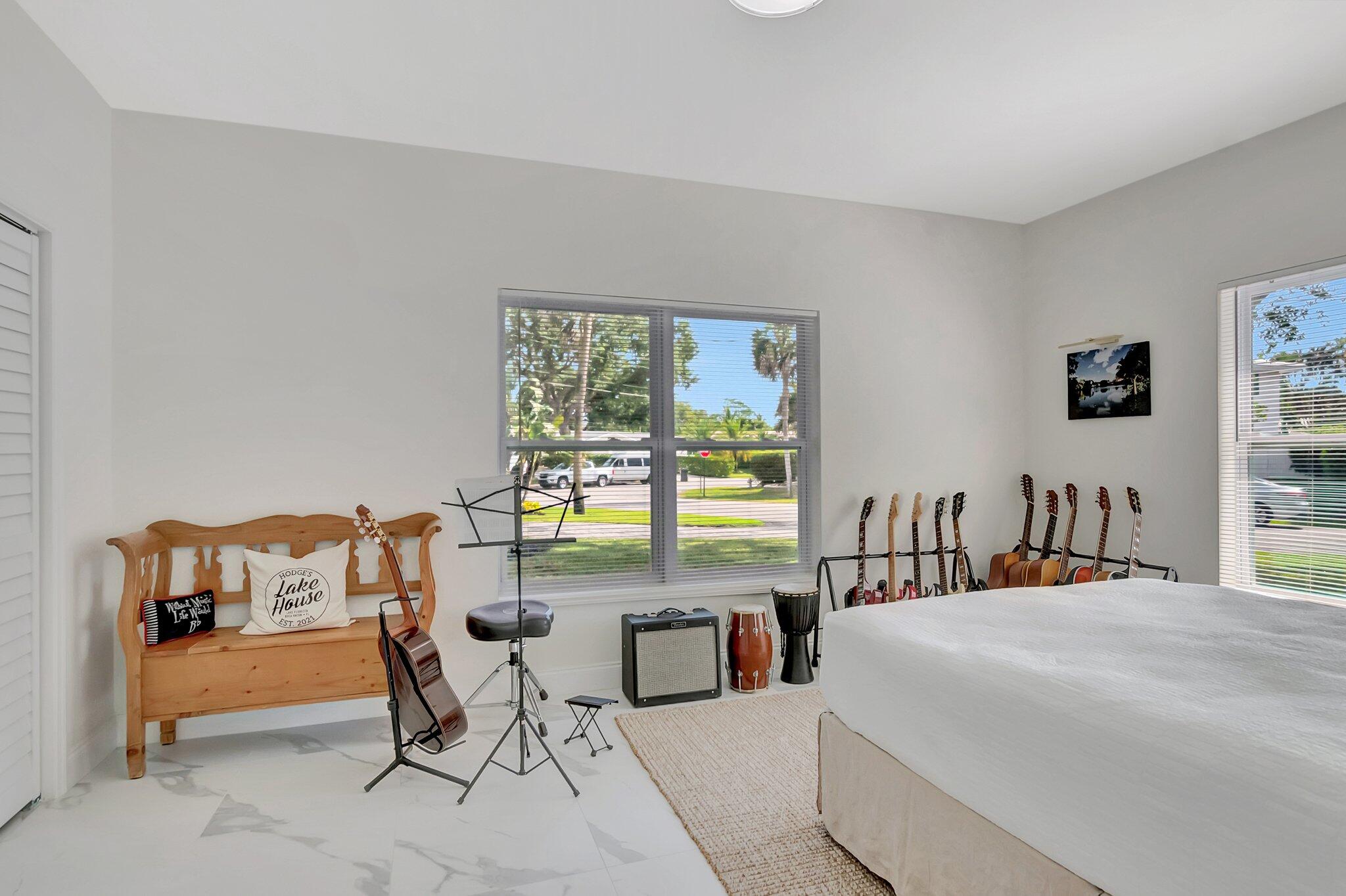 299 Northwest 10th Court Boca Raton, FL 33486 - Photo 23 of 42 a bedroom with a bed and a couch next to a window