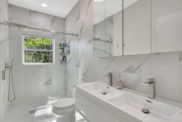 a bathroom with a sink a toilet and shower