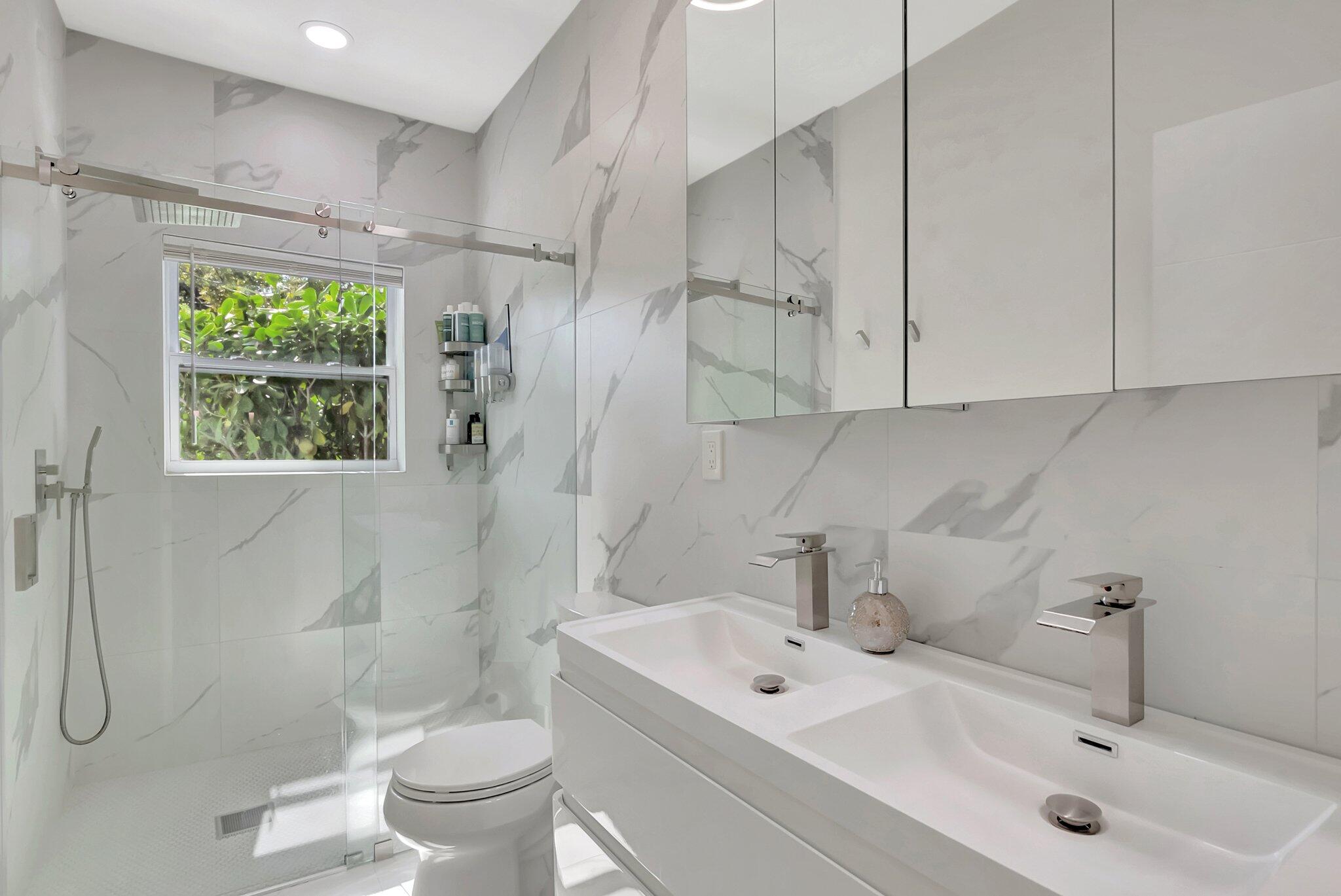 299 Northwest 10th Court Boca Raton, FL 33486 - Photo 25 of 42 a bathroom with a sink a toilet and shower