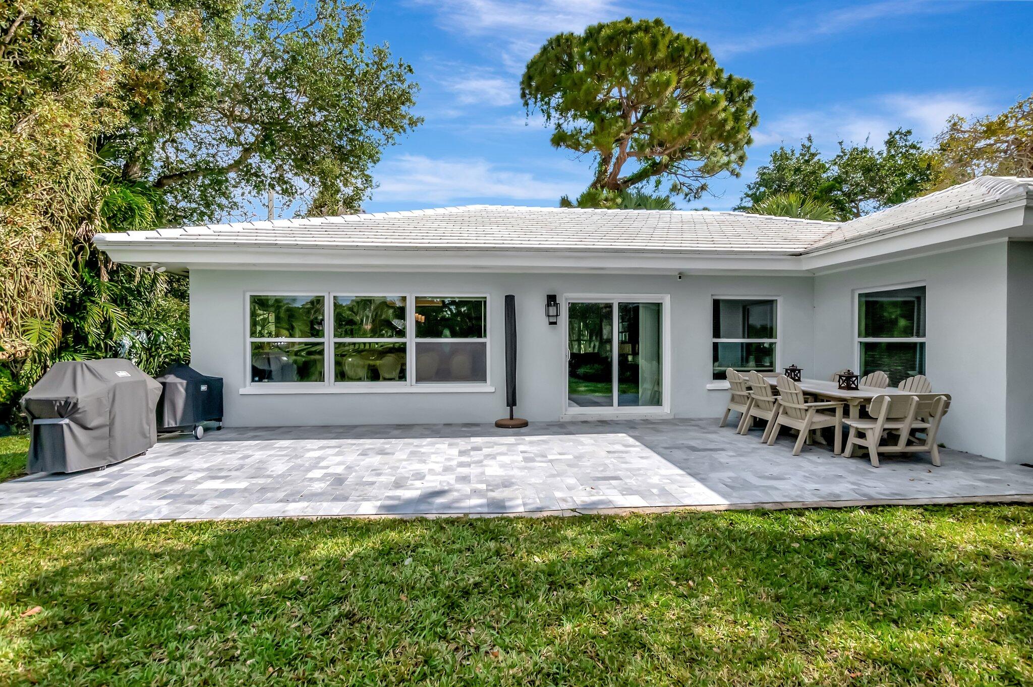 299 Northwest 10th Court Boca Raton, FL 33486 - Photo 30 of 42 a view of a house with patio and a garden