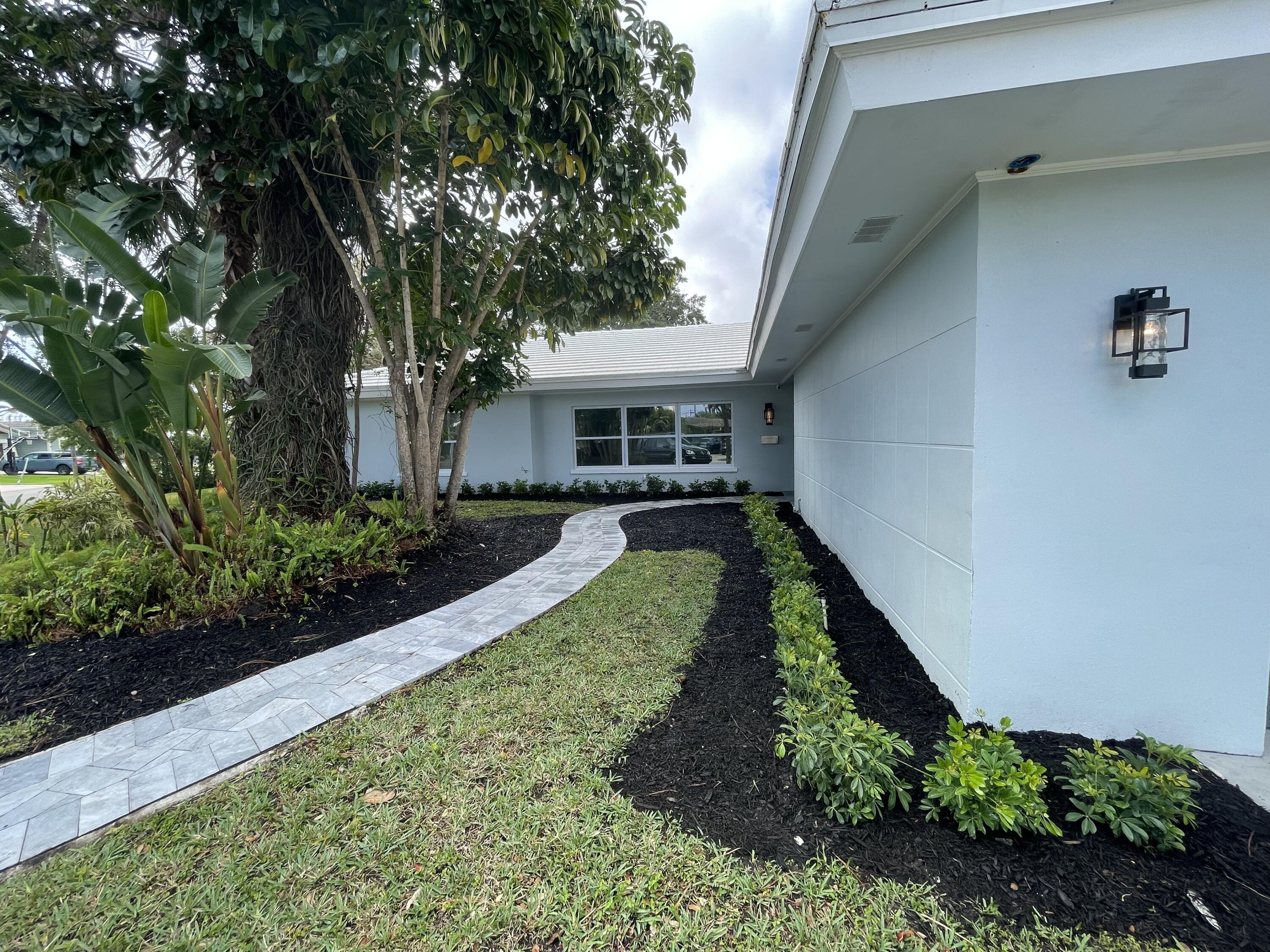 299 Northwest 10th Court Boca Raton, FL 33486 - Photo 4 of 42 a front view of a house with a yard