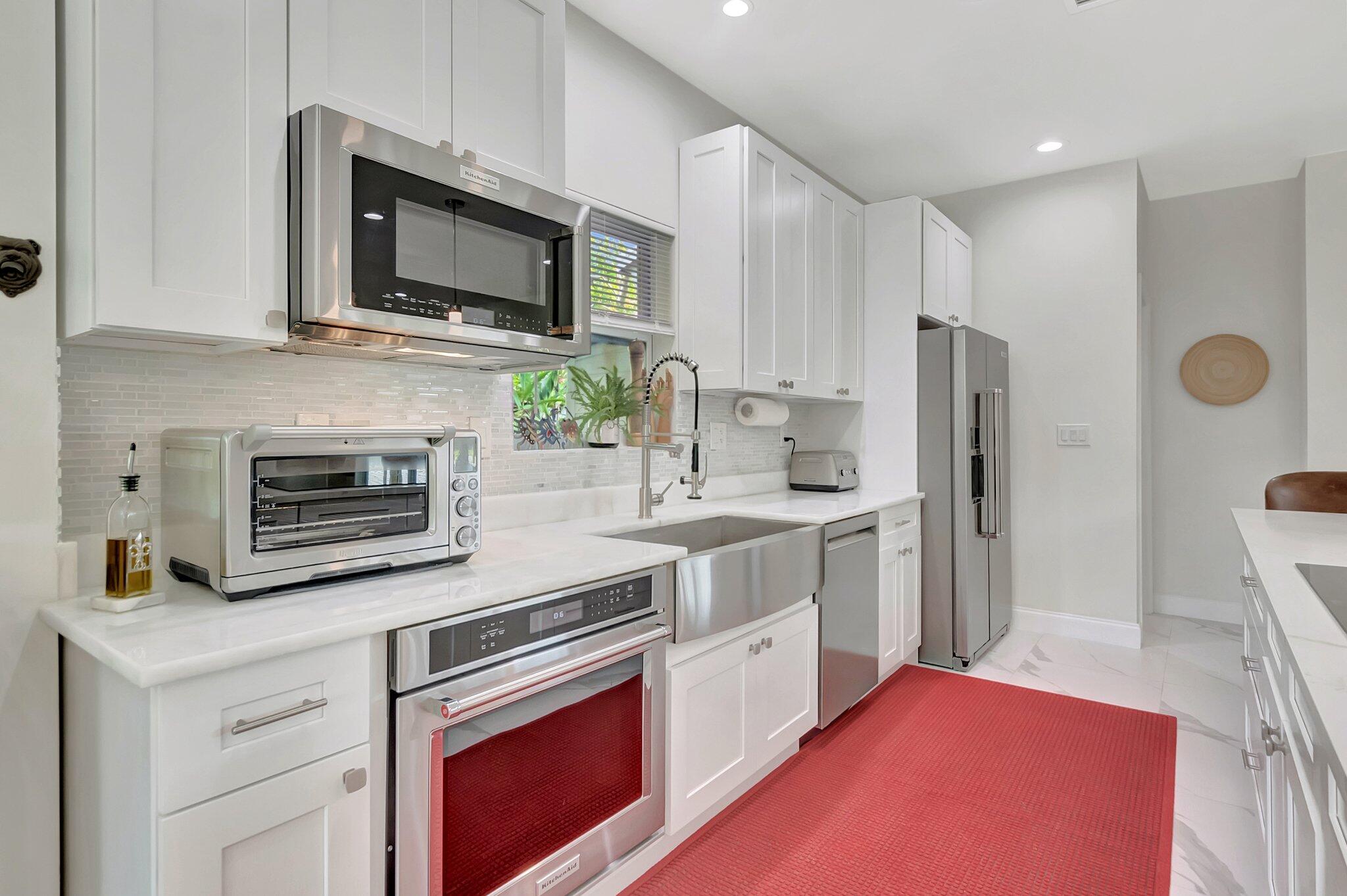 299 Northwest 10th Court Boca Raton, FL 33486 - Photo 9 of 42 a kitchen with stainless steel appliances a stove microwave and refrigerator