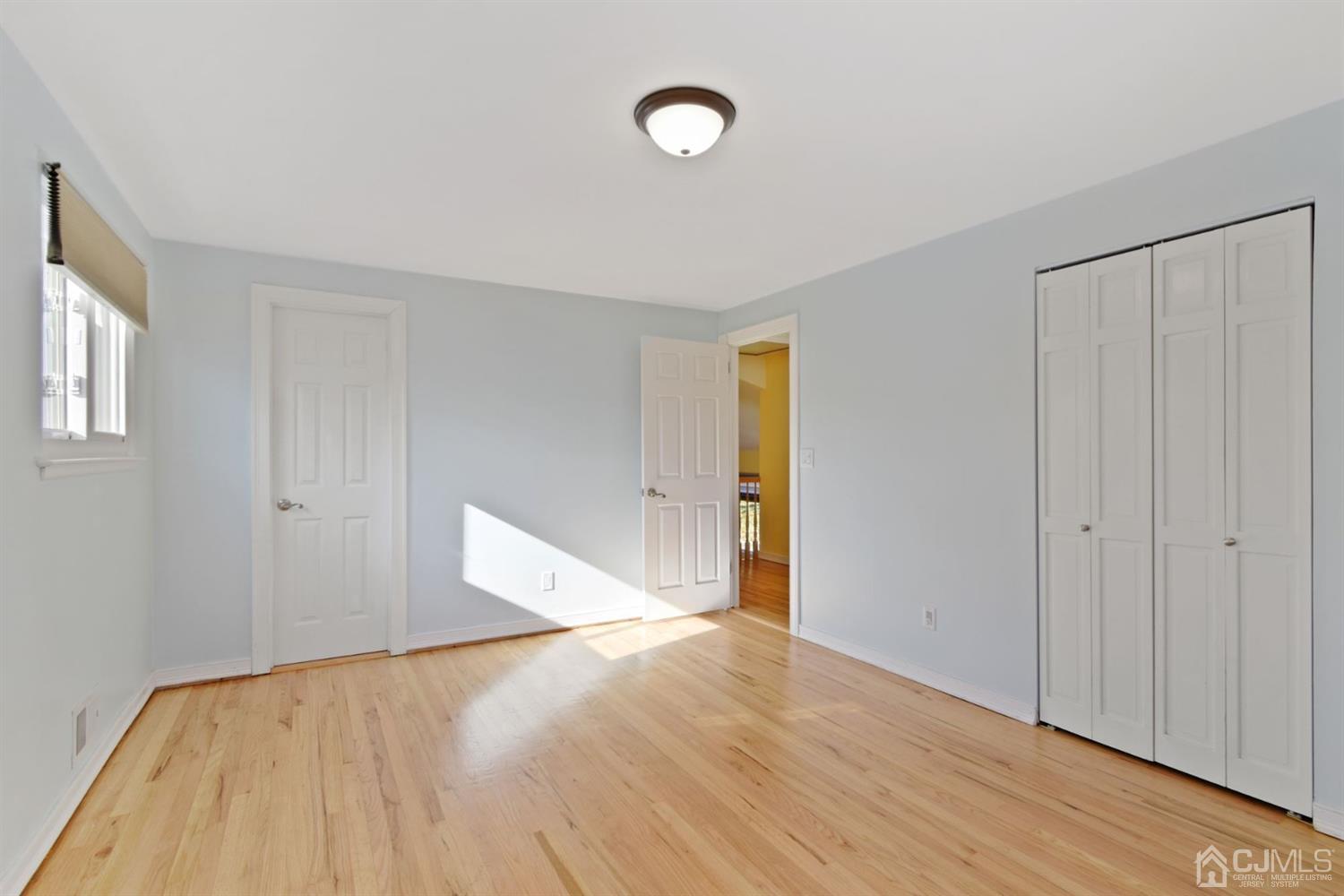 50 Gramercy Road Old Bridge, NJ 08857 - Photo 13 of 23 a view of an empty room with wooden floor and fan