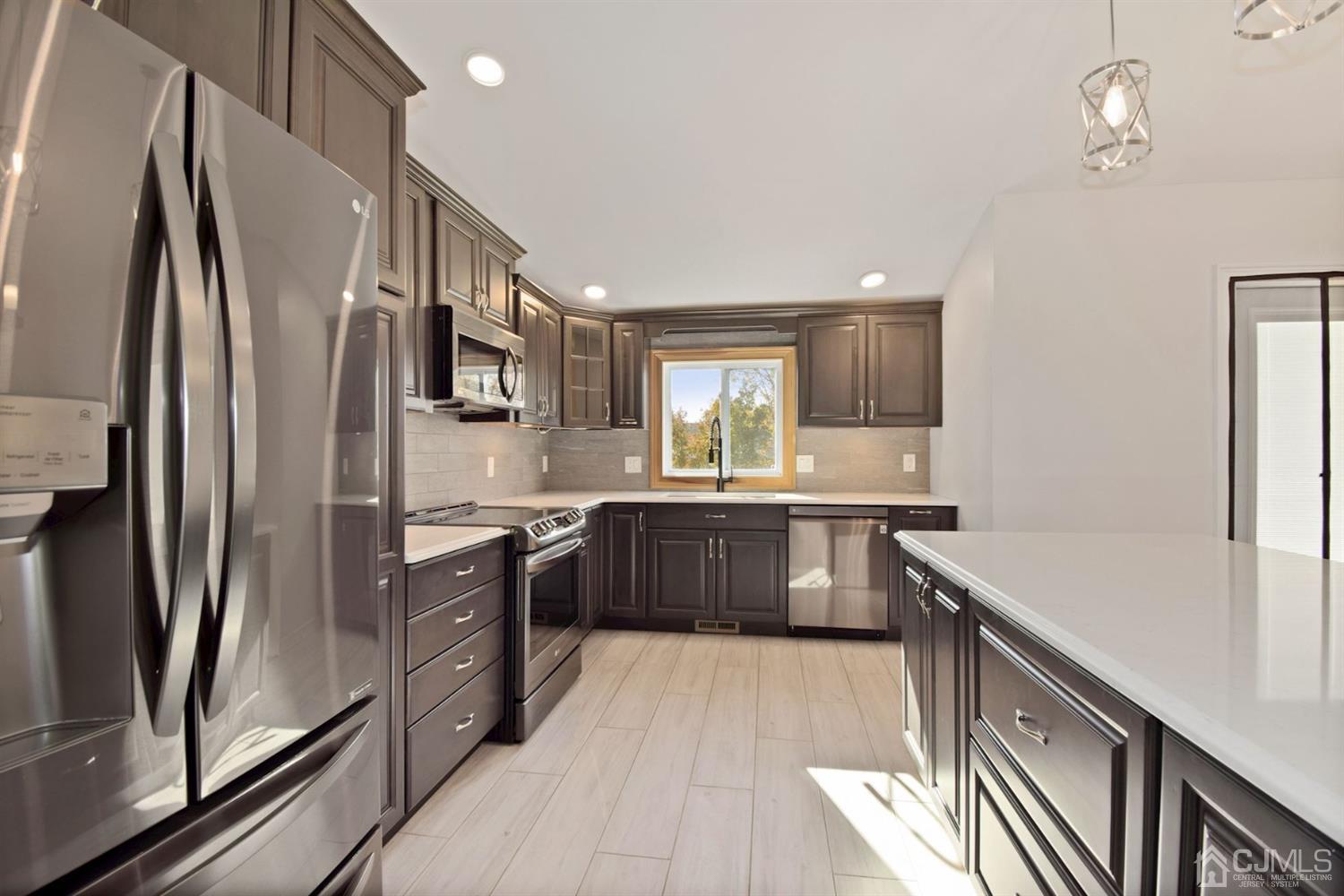 50 Gramercy Road Old Bridge, NJ 08857 - Photo 4 of 23 a kitchen with stainless steel appliances granite countertop a refrigerator a stove and a sink with wooden floor