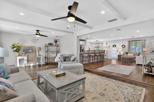a living room with furniture and view of kitchen