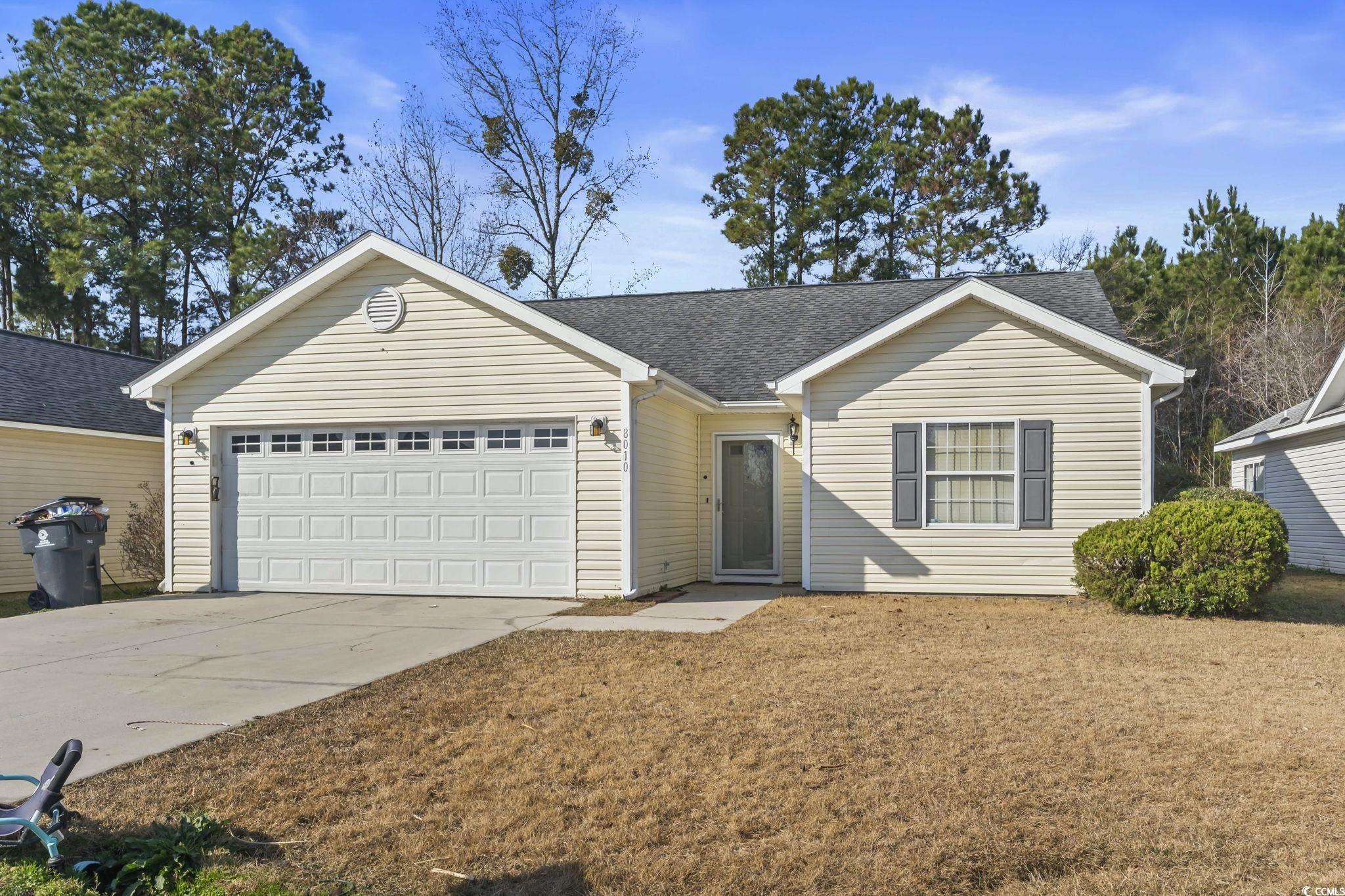 Ranch-style home featuring concrete driveway, roof with shingles, and a garage