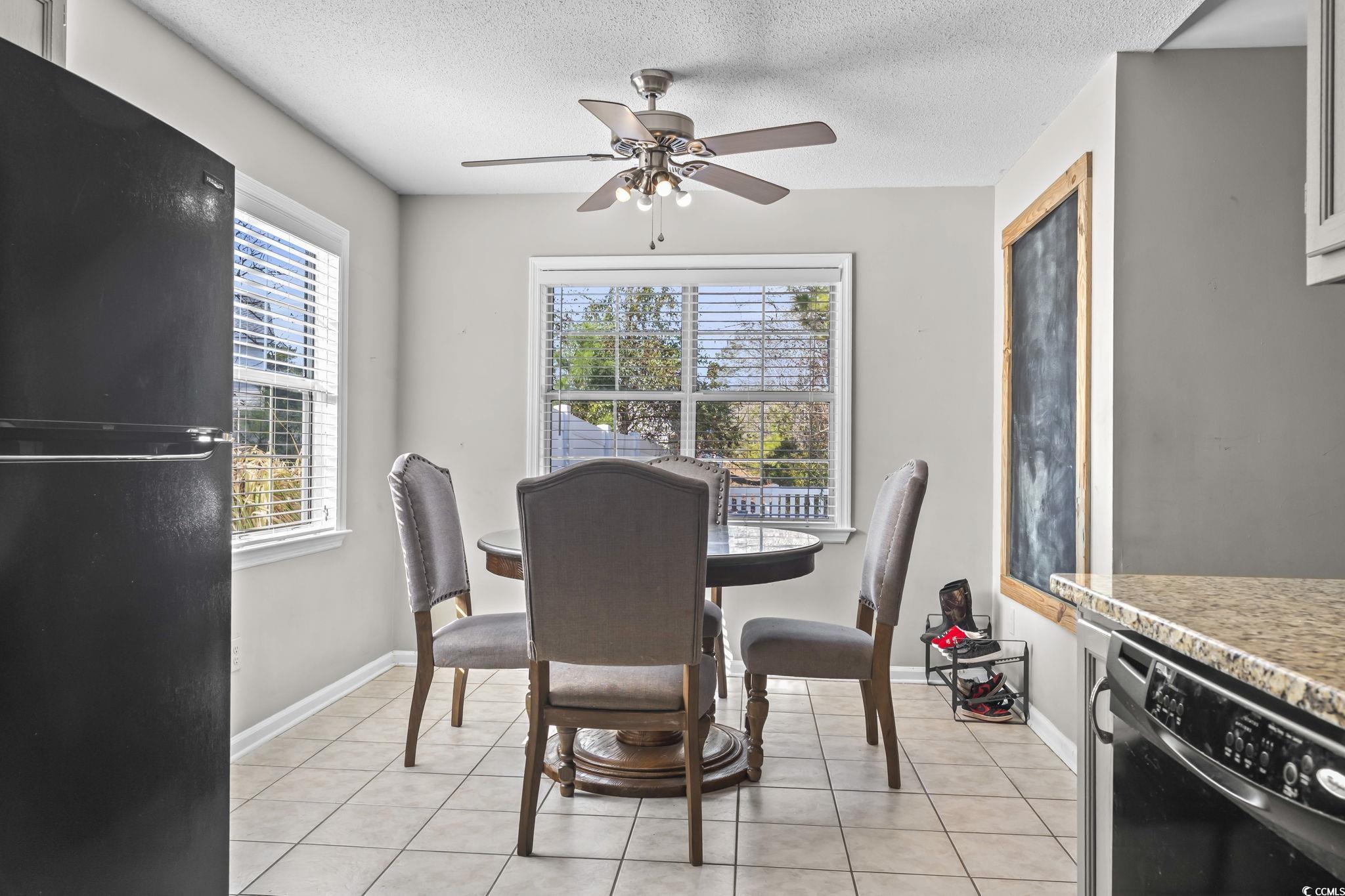 8010 Cone Court Murrells Inlet, SC 29576 - Photo 14 of 29 Dining space featuring light tile patterned floors, a ceiling fan, and a textured ceiling