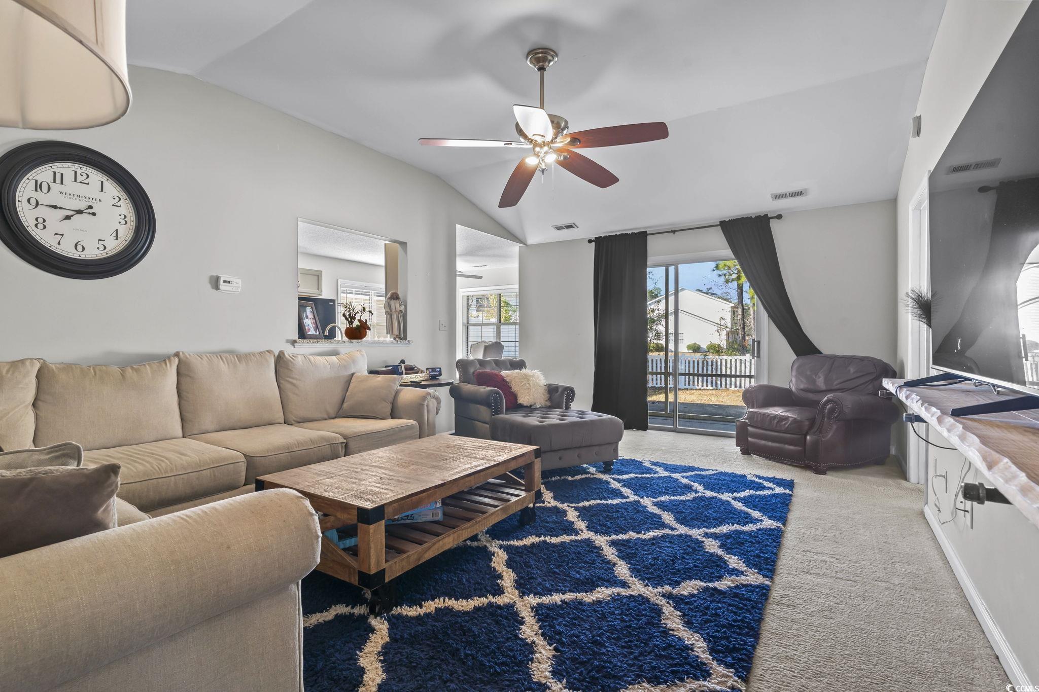 8010 Cone Court Murrells Inlet, SC 29576 - Photo 8 of 29 Living room with vaulted ceiling, light colored carpet, and a ceiling fan