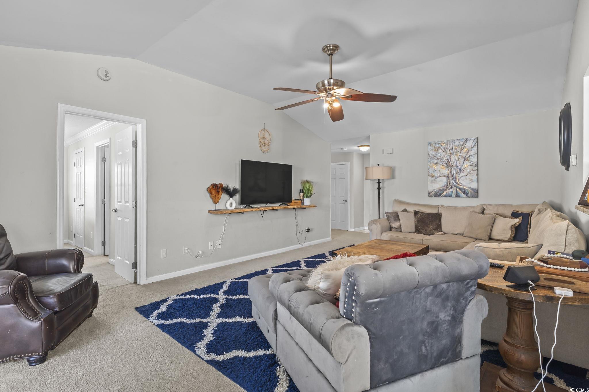 8010 Cone Court Murrells Inlet, SC 29576 - Photo 10 of 29 Carpeted living room featuring vaulted ceiling and a ceiling fan