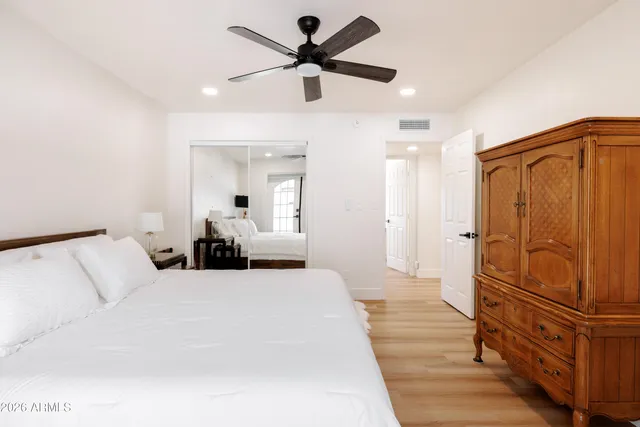 a bed room with a bed and a ceiling fan