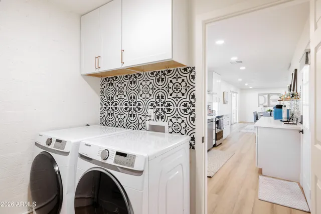 a view of washer and dryer with kitchen in the background