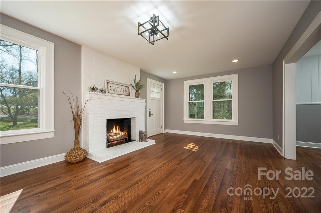 1141 Highway 64 Rutherfordton, NC 28139 - Photo 15 of 37 an empty room with windows a fireplace and wooden floor