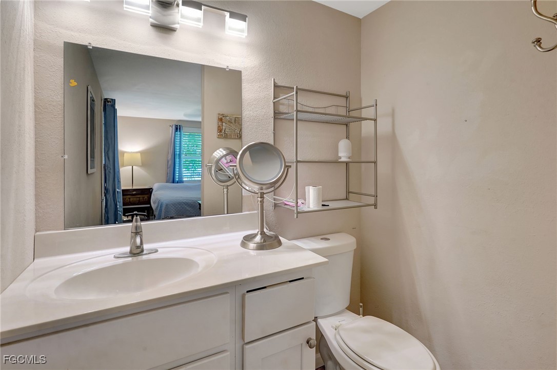7462 Pentz Road Bokeelia, FL 33922 - Photo 15 of 22 a bathroom with a toilet a sink and mirror