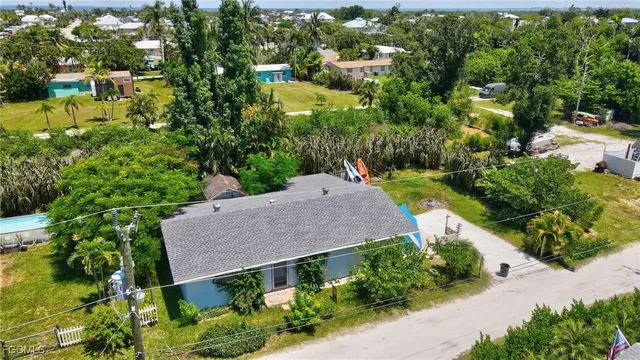 an aerial view of a house with a yard and large trees