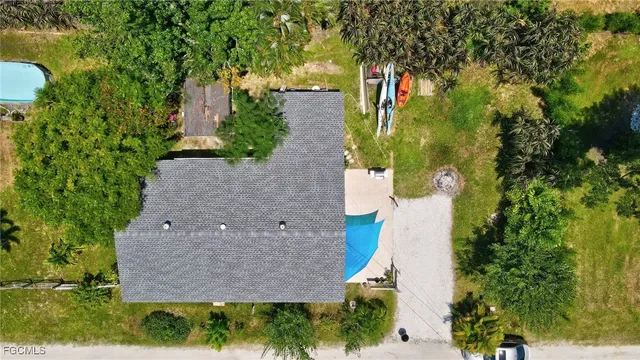 an aerial view of residential house with outdoor space and trees all around