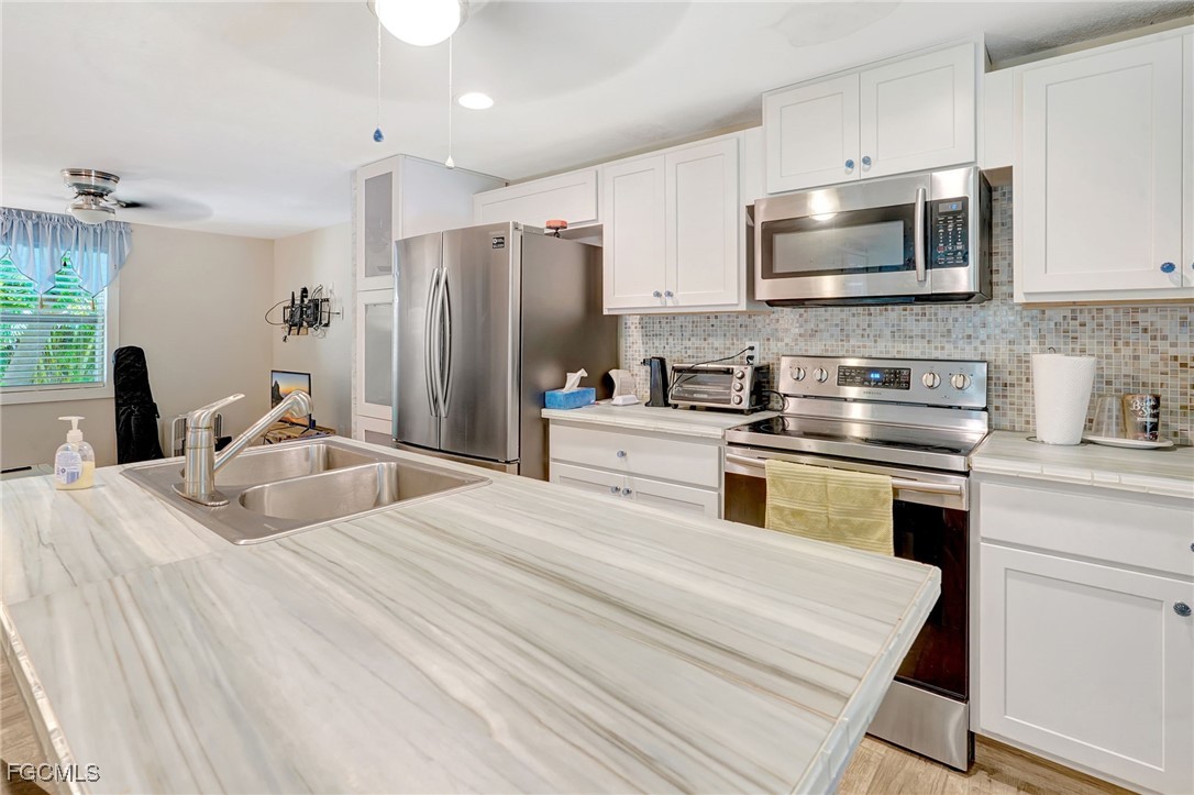 7462 Pentz Road Bokeelia, FL 33922 - Photo 7 of 22 a kitchen with appliances a sink cabinets and a counter top space