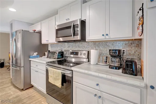 a kitchen with stainless steel appliances granite countertop a refrigerator a stove and a sink