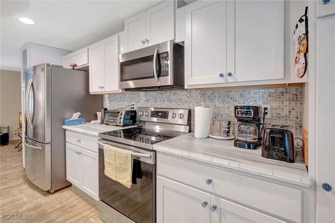 7462 Pentz Road Bokeelia, FL 33922 - Photo 8 of 22 a kitchen with stainless steel appliances granite countertop a refrigerator a stove and a sink