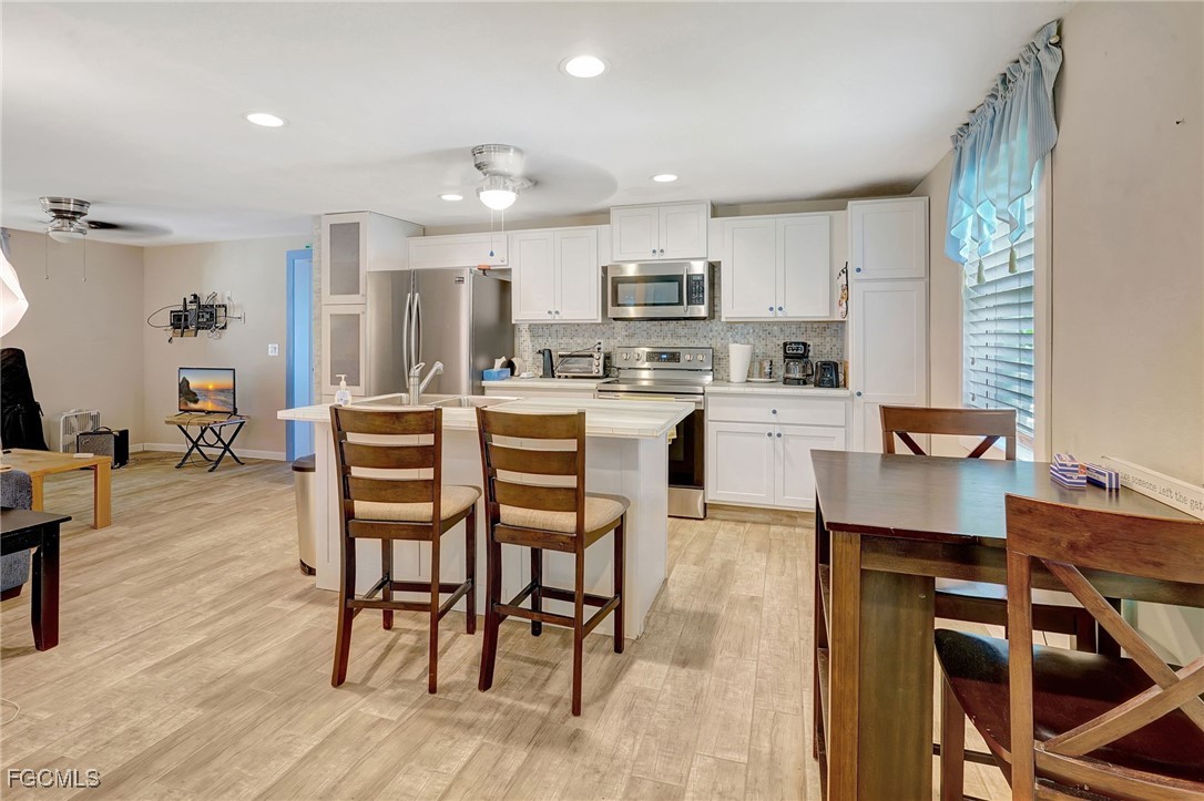 7462 Pentz Road Bokeelia, FL 33922 - Photo 9 of 22 a dining room with stainless steel appliances a dining table chairs and view living room