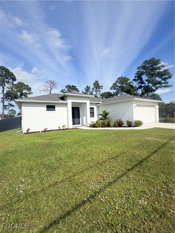 a view of a house with a yard and a large tree center in front of it