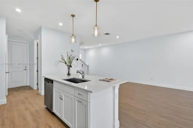 a kitchen with a sink a refrigerator and chandelier