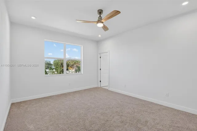 an empty room with a window and a ceiling fan